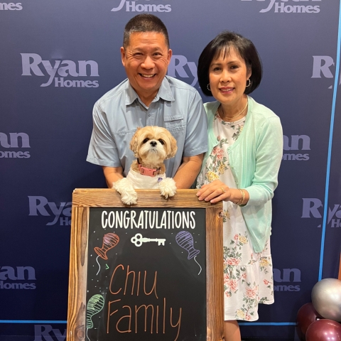 Family celebrates their new Ryan Homes purchase with a congratulatory sign
