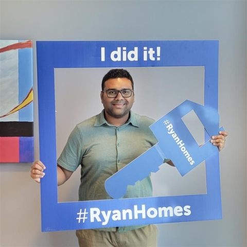 New Ryan Homes buyer celebrating homeownership, holding 'I did it!' frame