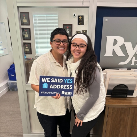 Homebuyers celebrating their Ryan Homes purchase inside a sales office